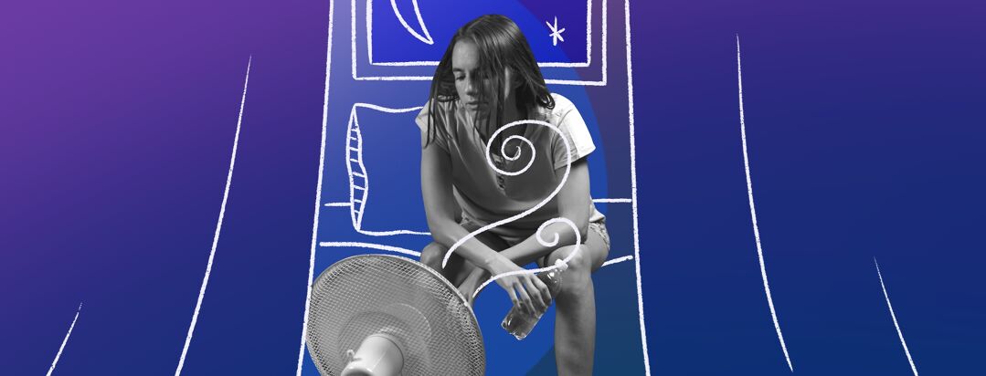 Woman sits on the edge of her bed holding a water bottle as a fan blows on her